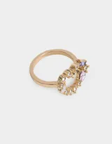 Anillo plateado con forma de corazón, adornado con strass blancos y gemas rosas y violetas.
