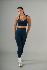 Conjunto deportivo negro, compuesto por un top con tiras cruzadas en la espalda y una calza de tiro alto con frunce en la parte trasera.
