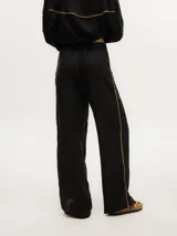 Pantalón de lino color marrón claro, de pierna ancha y tiro alto. Presenta un pequeño elástico en la parte trasera de la pretina y detalle al costado tipo naval.