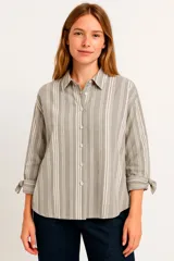Camisa a rayas verticales grises y blancas, de corte holgado, con cuello clásico, cierre frontal con botones y mangas 3/4 con lazo.