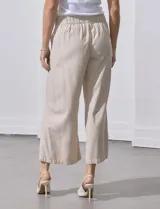 Pantalón crop de lino estampado con hojas en tonos verdes y azules. Tiene pretina trasera elastizada y bolsillos delanteros.