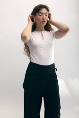 Top negro de jersey elastizado, de manga corta y corte ajustado, con abertura en forma de gota en el escote y frunces verticales en el frente.