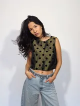 Remera corta de tafeta color verde militar con lunares de terciopelo negros, corte a la base y botón en la parte trasera.