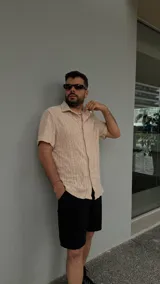 Camisa beige de crochet con cuello clásico y mangas cortas.