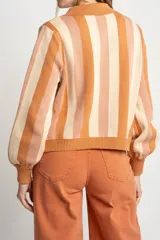 Cárdigan tejido con cierre frontal, diseño a rayas horizontales en tonos naranja, beige y rosa, cuello tipo polo y mangas abullonadas.