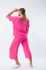 Conjunto fucsia de lino, compuesto por una blusa de mangas cortas y un pantalón capri con lazo en la cintura.
