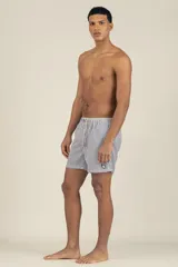 Short de baño a rayas verticales azules y blancas, con cintura elástica ajustable con cordón y logo bordado en la pierna.