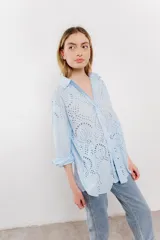 Camisa celeste de algodón liviano con bordado calado tipo broderie, manga larga con puño angosto y botones al frente.