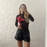 Top de microtul negro con estampado de flor roja.