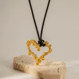 Collar con cordón negro y dije de corazón dorado con efecto dripping.