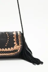Cartera bandolera negra de cuero con diseño trenzado en el frente y flecos en gamuza. Tiene correa trenzada con terminación y forro de algodón.