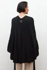 Capa negra tejida con volados.