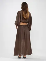 Blusa corta celeste de tejido arrugado liviano, con cuello mao, botones al frente, mangas abullonadas y ruedo elastizado.