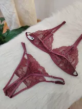 Conjunto de lencería de encaje color bordó, compuesto por un corpiño triangular sin aro y una bombacha less con tiras finas.