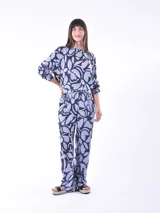 Blusa de mangas largas con estampado de hojas en tonos celeste y azul marino, con lazo en la cintura.