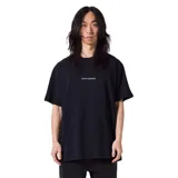 Remera negra de corte oversized con estampado frontal con el texto "former merchandise" en blanco.
