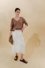 Falda midi color blanco, tipo pareo, confeccionada en lino y algodón.