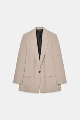 Blazer negro de manga larga con cuello solapa y cierre frontal de un solo botón. Presenta bolsillos delanteros con solapas.