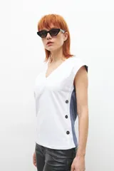Remera beige melange de manga corta, con botones en los laterales y corte relajado.