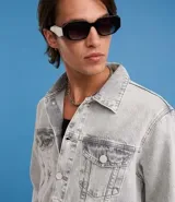 Campera de jean de hombre, modelo regular, con efecto desteñido en tonos grises claros. Presenta cuello inglés, manga larga, abotonado frontal y dos bolsillos con solapa y botón en el pecho.