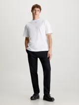 Remera blanca de algodón con cuello redondo y logo Calvin Klein nano estampado en el pecho.