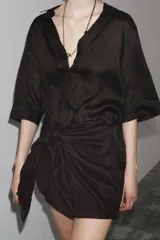 Camisa marrón de corte recto, con cuello solapa, manga corta y cierre frontal con botones.