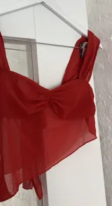 Top color terracota con breteles finos y escote drapeado.