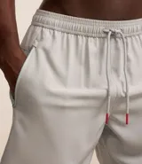 Bermuda deportiva negra sin estampado, con cintura elástica ajustable con cordón, y bolsillo lateral con cierre de cremallera contrastante.
