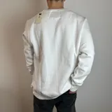 Buzo blanco de cuello redondo con puños y cintura acanalados. Estampado frontal con palmeras y texto 'Surf Point Santa Barbara'.