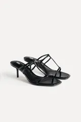 Sandalias de tacón fino color negro charol, con tiras delgadas en el empeine y punta cuadrada.