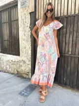 Vestido largo con estampado paisley multicolor, escote en V y mangas cortas con volados. Tiene corte recto y ruedo con volados.