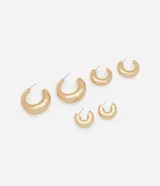 Set de tres pares de aros tipo argolla gruesa, con forma de media luna o 'chunky hoops', en tono dorado. Los aros varían en tamaño de forma gradual, desde el más grande al más pequeño. Cuentan con poste para perforación.