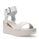 Sandalias de plataforma marca Bottero en color blanco hueso, con una tira ancha sobre los dedos y correa ajustable al tobillo mediante una hebilla metálica. La plataforma es de tono claro con suela dentada y cuenta con un detalle lateral de corcho decorado con tachas plateadas.