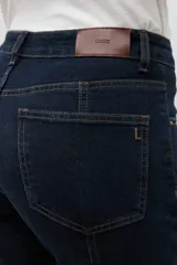 Pantalón de jean oscuro de tiro alto, corte recto y pierna ancha, con costuras verticales marcadas en el frente.