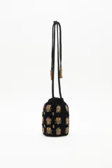Cartera tipo bombonera negra de terciopelo con bordado de lentejuelas y canutillos dorados con forma de insectos. Tiene cordón de ajuste con borlas de canutillos dorados y correa de mano.