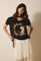 Remera negra de algodón con estampa de un felino dentro de un círculo con rayos de sol.