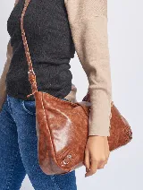 Cartera bandolera marrón de cuero sintético con correa ajustable y cierre superior.