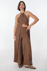 Conjunto de top halter con abertura en el abdomen y falda cruzada con ruedo desflecado, color fucsia.