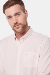 Camisa de lino color beige, de manga larga, con cuello clásico y bolsillo en el pecho.