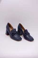 Zapato clásico de cuero azul marino, con aplique decorativo en el empeine y taco cuadrado.