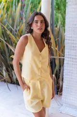 Conjunto de dos piezas color rojo vibrante, compuesto por un chaleco sin mangas con escote en V y botones frontales, y un short de tiro alto con pliegues y bolsillos laterales.