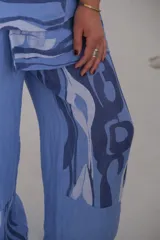 Pantalón celeste con estampado abstracto en tonos azules y blancos.