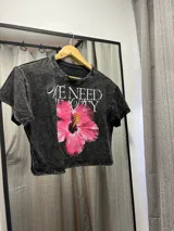 Remera negra jaspeada de corte cropped con estampa de la portada de la revista Vogue con imagen de Frida Kahlo intervenida con un rayo azul.