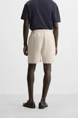 Bermuda negra regular fit confeccionada en tejido de algodón con estructura. Cintura elástica ajustable con cordón, bolsillos laterales y bolsillo trasero de vivo.