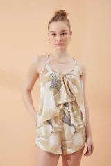Short de poliéster con estampado color beige y diseño de palmeras.