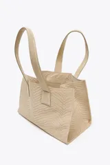 Bolso shopper color beige con diseño trenzado y doble asa de hombro. Cuenta con un bolsillo interior con cierre de cremallera y cierre principal con clip.