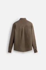 Camisa color arena de lino con cuello abotonado, manga larga con puños abotonados, corte regular y bajo con aberturas laterales.