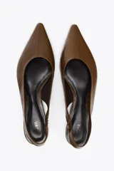 Zapato destalonado tipo bailarina, color marrón, de piel, con punta fina y tira trasera con elástico lateral.