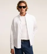 Camisa blanca de algodón, manga larga con botonadura frontal y cuello camisero.