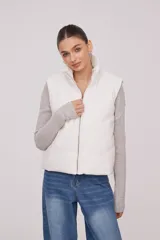 Chaleco blanco con cuello alto y cierre frontal con cremallera.